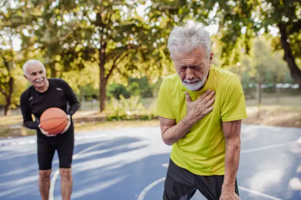 Photo of a senior man on the basketball field having heart attack