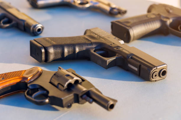 武器の中のテーブルの上の銃、選択的な焦点。犯罪ニュースの背景。 - gun ストックフォトと画像