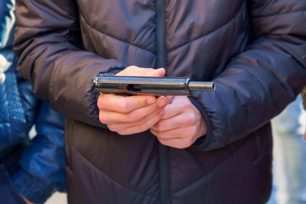 istock A gun in the hands of a young man, selective focus. Reloading weapons. Shooting training. Background 1365229455