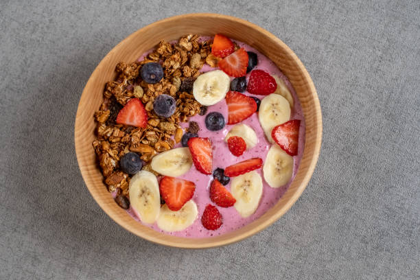 Smoothie bowl with fresh berries, bananas, strawberries, nuts, seeds and homemade granola for healthy vegan diet breakfast Smoothie acai bowl ACAI BOWL stock pictures, royalty-free photos & images