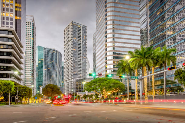 Cars drive in the Financial District of downtown Miami Florida USA in the evening.