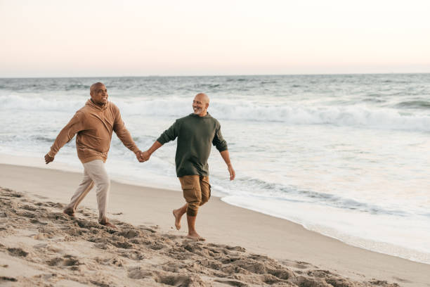 couple gay senior sur la plage - tourist senior adult senior couple couple photos et images de collection