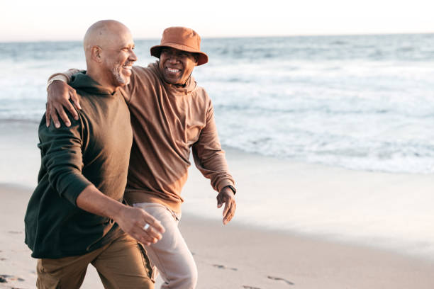 istock Senior couple walking on a beach together 1365232036