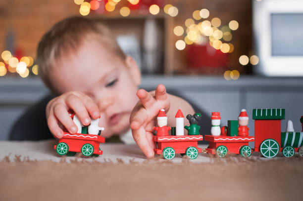 istock Toddler boy playing with Christmas train in kitchen close-up... 1365234783
