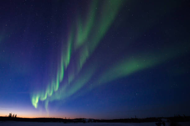aurora boreal al atardecer en canadá - yellowknife fotografías e imágenes de stock