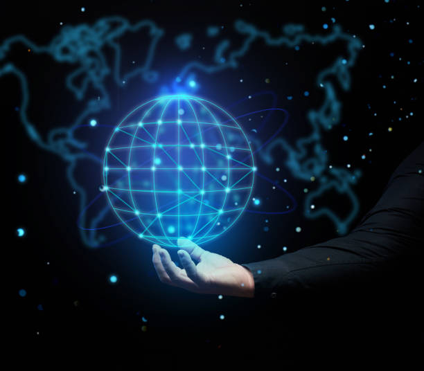 istock a man's hand holds a holographic globe on a dark blue background. Concept of globalization, world internet network, barrier-free 1365235917
