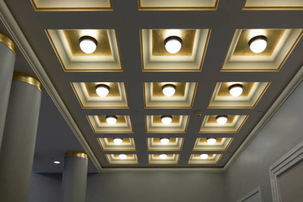 geometric ceiling with square boxes and round lamps in a row and column of hall - light fixture imagens e fotografias de stock