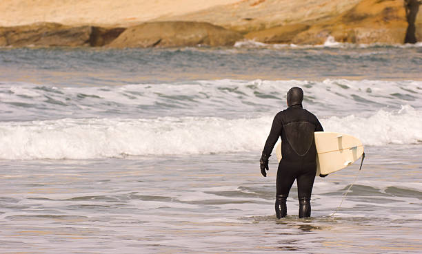 surfeur propose sa planche de surf à travers la - bodysurfing photos et images de collection