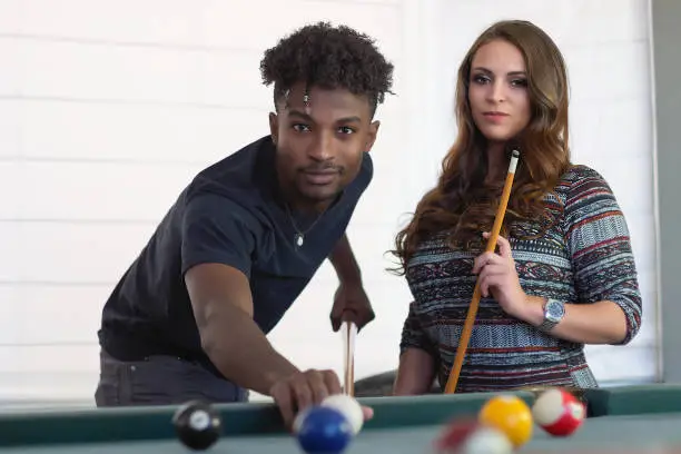 young women and men portrait team playing pool table billiards players fun activity recreation bar ball game