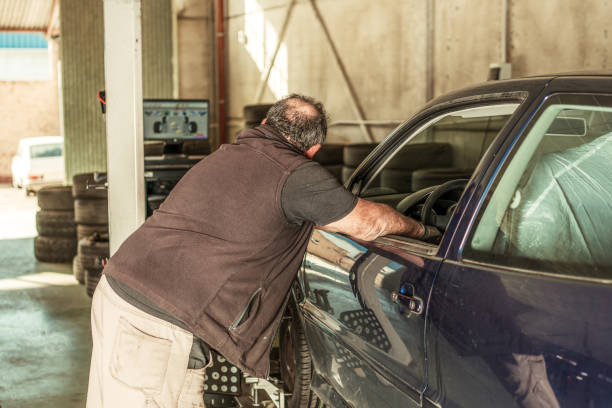 istock Mechanic checking that a car's steering is aligned in a workshop 1365246141