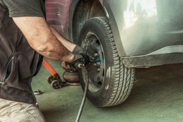 istock Mechanic using an electric screwdriver to remove a wheel in a garage 1365246991