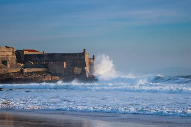 istock Large waves crash into a fortress near a beach. Carcavelos beach 1365248681
