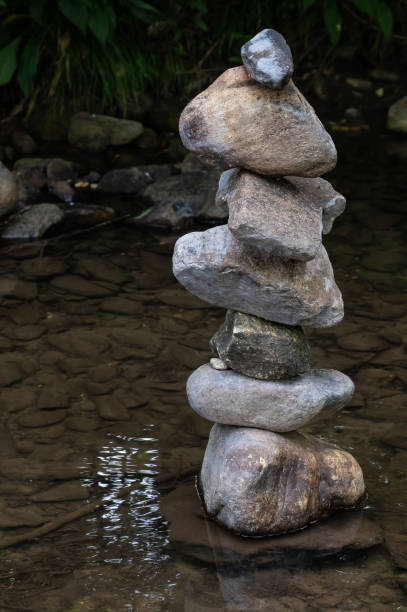 istock Rough Stone Cairns Standing Proudly in the Shallow Creek Water 1365249654