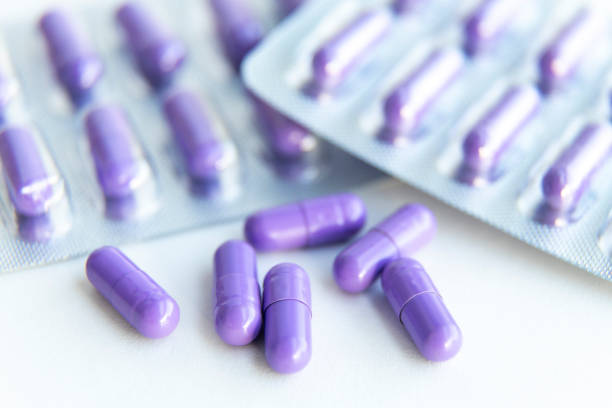 compresse antibiotiche non confezionate e capsule in blister - pill purple capsule vitamin pill foto e immagini stock