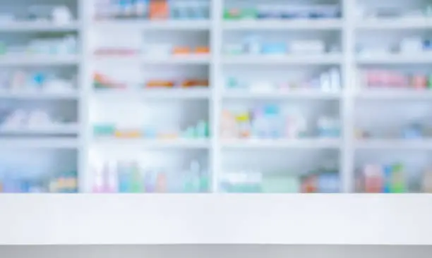 Photo of Empty white counter with pharmacy drugstore shelves blurred background