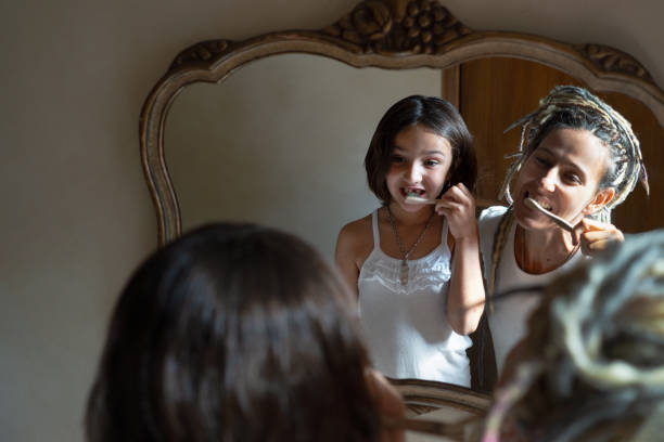 istock Mother teaches her daughter how to brush her teeth. 1365254295