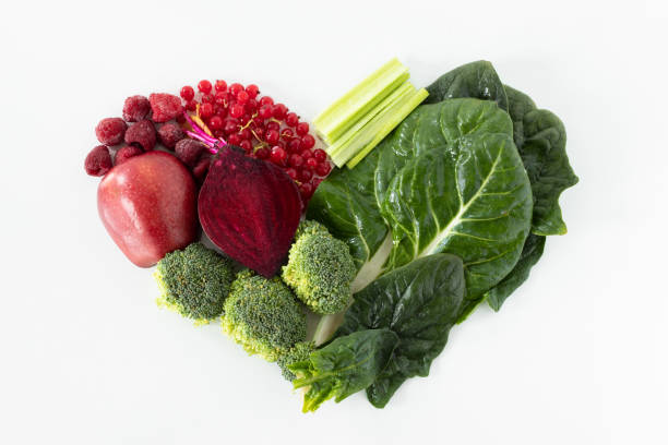 istock Creative heart shape from various fresh red and green vegetables and fruits isolated on white background 1365258575