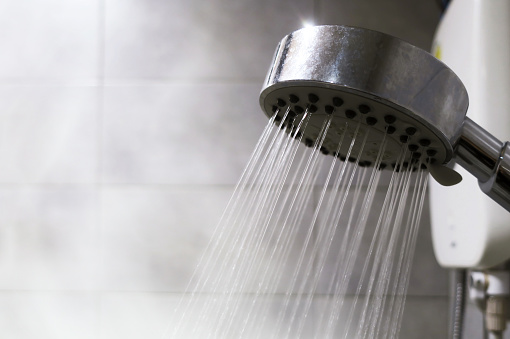 Many small water stream from shower in bathroom with warm smoke vapor for refresh and cleaning