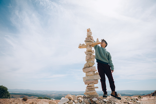 Boy building large rock totem