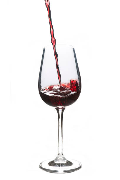 Glass of red wine while pouring wine stock photo