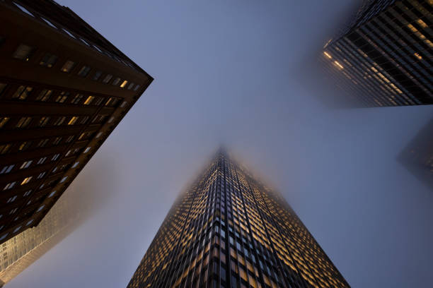 edifícios de escritórios na neblina - skyscraper low angle view new york city night - fotografias e filmes do acervo