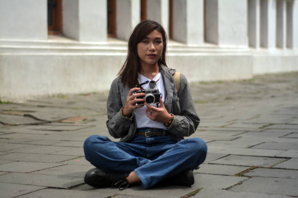 portrait d’une femme indonésienne prenant une photo à l’aide d’un appareil photo analogique - photographer women retro revival camera photos et images de collection