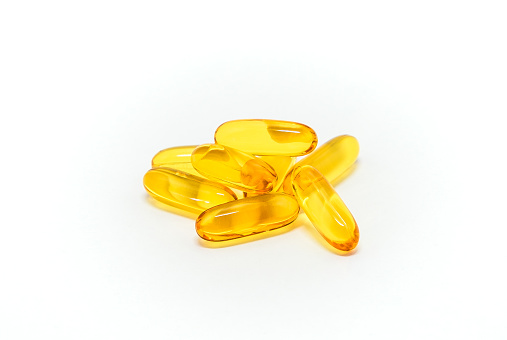 Front view of fish oil capsule on white background. Vitamin supplement cod liver gel omega.