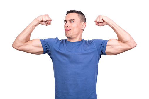 Studio portrait with white background of a male gesturing to be strong raising the biceps
