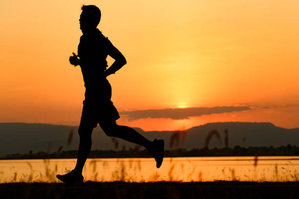 a man running Silhouette sunset at lake and Mountain