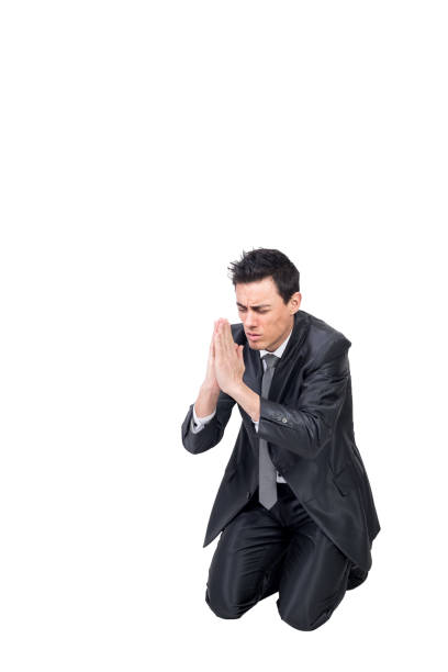 istock Well dressed man praying on knees in studio 1365278714
