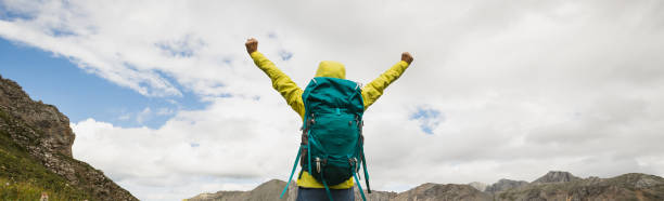 istock Successful woman backpacker hiking on alpine mountain peak 1365286850