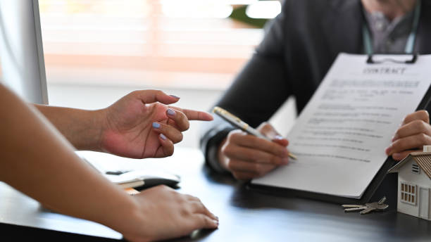 istock Financial advisor consulting  with clients about new house and showing contract document. 1365288950