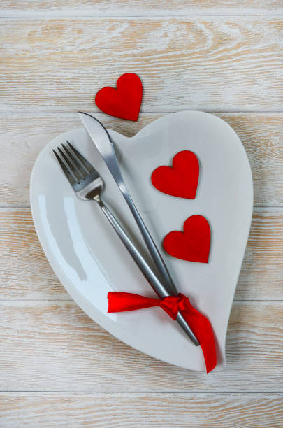 istock valentines day table setting flat lay with love white ceramic plate shape heart, festive decoration, fork and knife 1365290711
