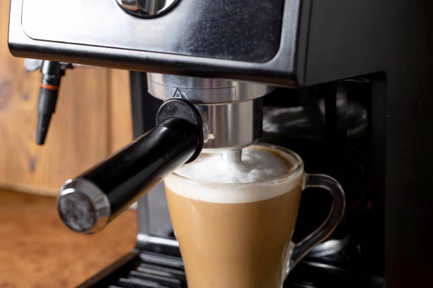 istock Making coffee with cappuccino milk in a cappuccino machine with a manual cappuccino maker on the background of a wooden table top. Close-up 1365290812