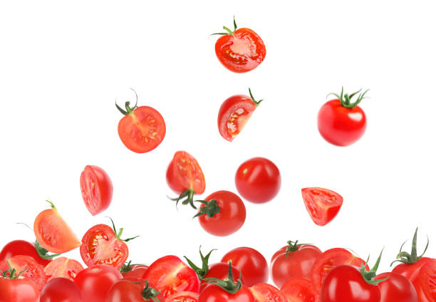 istock Many cut and whole tomatoes falling on white background 1365291899
