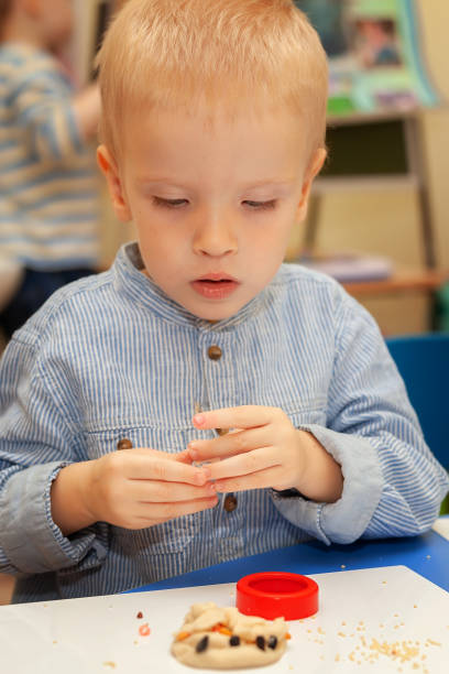 istock a boy in daycare makes a craft from plasticine 1365292778