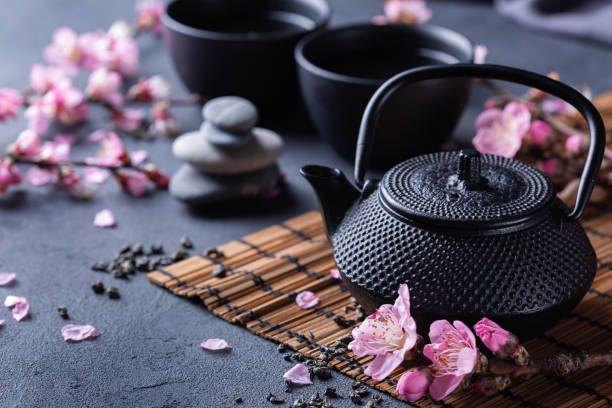 Teapot and tea cups with blooming almond tree branches