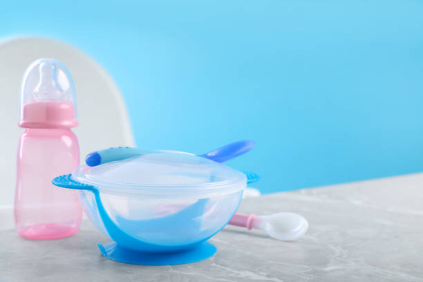 istock Set of plastic dishware on grey table. Serving baby food 1365296603