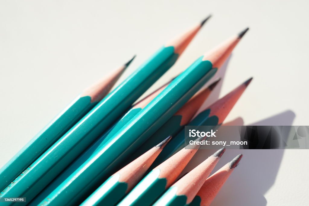 Green set of graphite pencils on sunny white table Green set of graphite pencils on sunny white table. Abstract Stock Photo