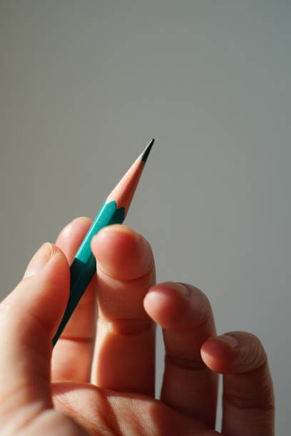 istock Green graphite pencil in female hand with sunlight 1365297201