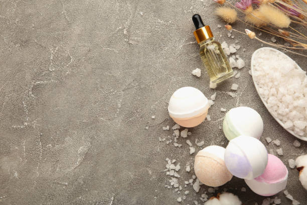 Composition with bath bombs, sea salt, dry flowers on grey background