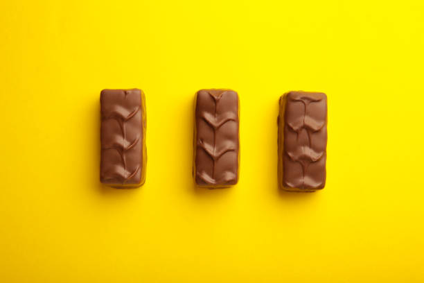 istock Mix of chocolate bars on yellow background. Top view. 1365302715