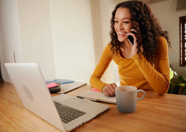 istock African American female speaking on cellular device while on business call using laptop 1365302910