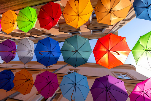 Tarnow, Poland - July 24, 2021:Colorful decorative umbrellas hanging over Piekarska street near Town Square, modeled on the Portuguese \