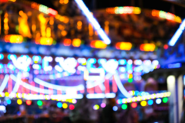 焦点を当て解除された明るいライトは、夜の楽しいカーニバルで点滅します。アミューズメントパークボケライトアットナイト。ナイトライフエンターテイメント - ferris wheel wheel blurred motion amusement park ストックフォトと画像