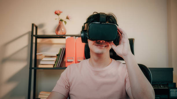istock Man using Virtual Reality goggle Headset travel on metaverse digital cyber world at home 1365304428