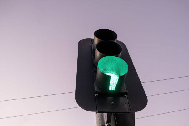 istock Looking up at green traffic light against the sky at sunset with copy space 1365304705