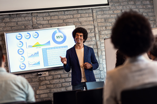 Business man holding presentation to diverse group of people.