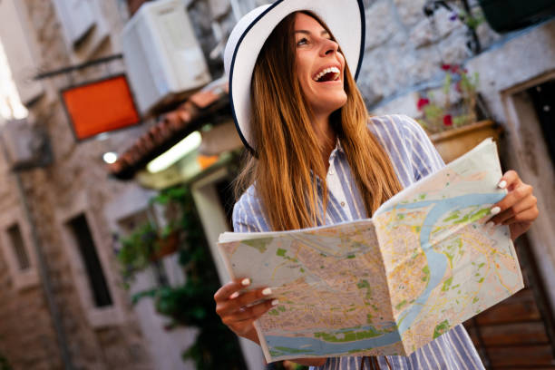 istock Young female tourist with map looking for a way on summer vacation 1365305763