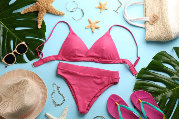 istock Beautiful pink bikini and beach accessories on light blue background, flat lay 1365306852